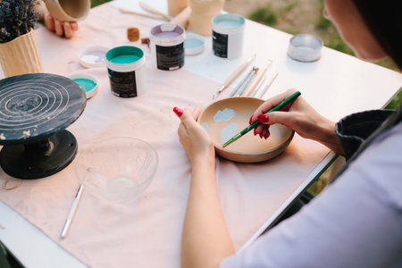 Ceramic bowl decorated with blue paint designs shows detailed process of pottery painting of handmade ceramics. Ceramic bowl with painted blue designs inside. Blue paint drawings inside ceramic bowlの写真素材