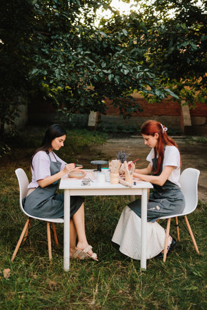 Pottery and Ceramic Art. Painting Blue Clouds on Clay Bowl. Ceramic bowl is hand-painted with light blue clouds, showcasing creative pottery decorationの写真素材