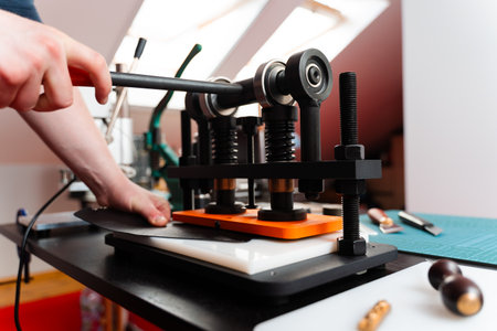Leather pressing provides strength and detail to handmade designs, creating premium results for wallets, belts, and accessories. Craftsman uses press machine to imprint patterns into leatherの写真素材