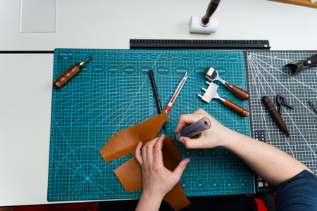 Craftsman applies dark edge finish to leather cut, adding strength, smoothness, and sophistication....