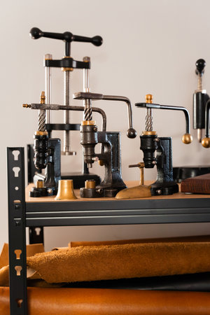 Retro leathercraft presses and shelves of cowhide hides create a true artisan studio. Leather rolls...