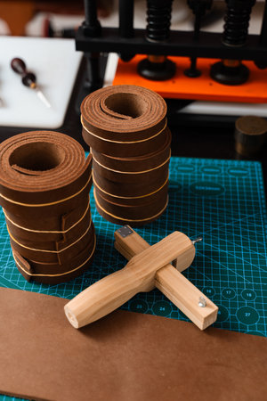 Leather rolls and strap cutter lie on cutting mat, ready for trimming strong belts and leather...