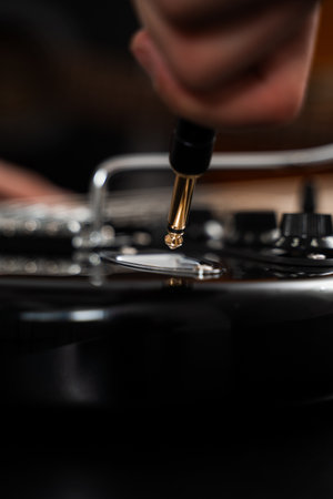 Jack cable is plugged into the black electric guitar, activating its signal path for rich tones and...