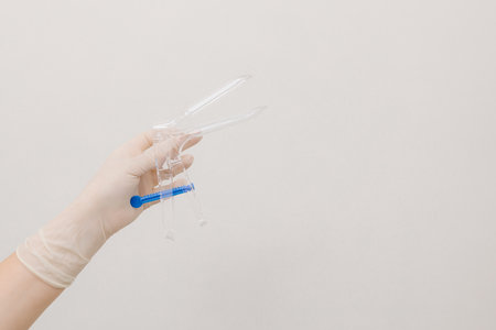 Gynecologist prepares speculum and brush for cervical screening. Close-up of gynecology tools used...