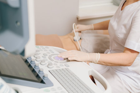 Gynecologist uses ultrasound equipment for reproductive health evaluation. Gynecologist performs an abdominal ultrasound on a relaxed patient. Abdominal ultrasoundの写真素材