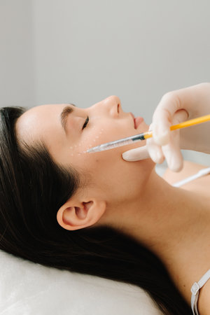 Facial mesotherapy to rejuvenate skin and improve skin health and appearance. Cosmetologist is making facial mesotherapy injections for girlの写真素材