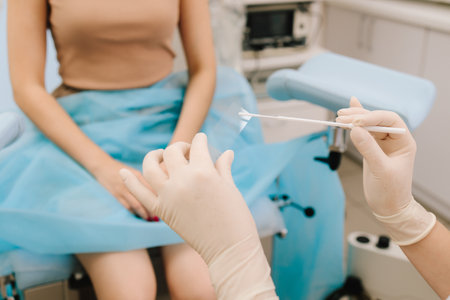Gynecologist prepares a Pap smear slide with collected cells. A Pap smear sample is applied to a glass slide in the lab. Cytology sample is carefully placed on a glass slide for analysisの写真素材
