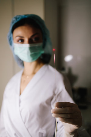 Precision laser therapy targets damaged skin cells to stimulate collagen regeneration and renewal. Doctor with laser for microneedling RF therapy in medical clinicの写真素材