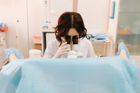 Patient undergoes gynecological exam with modern colposcopy equipment. colposcopy exam at gynecology clinic. Gynecologist performs colposcopy with professional microscopeの写真素材