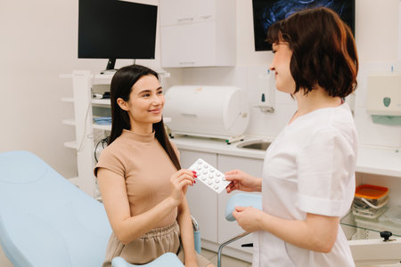 Contraceptive methods presented during a medical consultation. Gynecologist is holding contraceptives. Gynecologist shows contraceptives including pills and a condomの写真素材