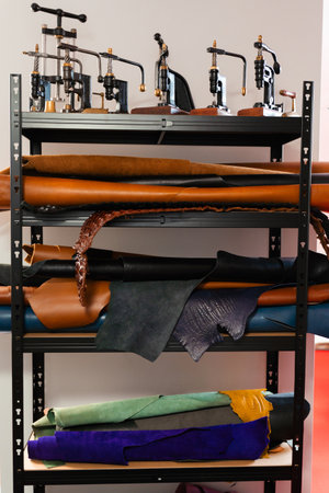 Leather rolls and classic vintage presses fill the craftsman workshop shelves. Retro leathercraft...