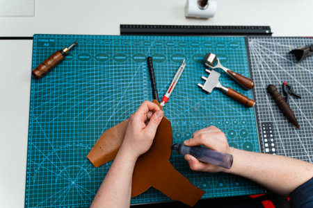 Edge finishing with dye marker. Artisan applies edge dye to leather piece, enhancing durability....