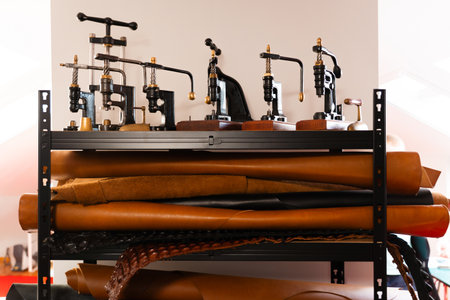 Retro leathercraft presses and shelves of cowhide hides create a true artisan studio. Leather rolls...