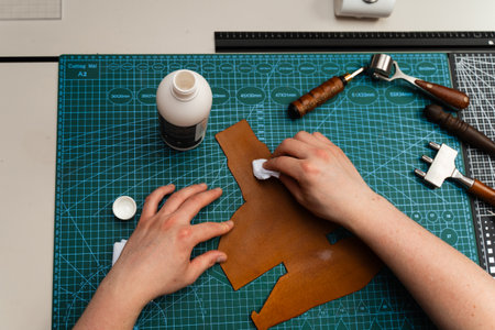 Conditioning leather with a cloth restores shine, flexibility, and strength. Leather dye or conditioner application protects surface and color. Applying conditioner or dye to leather with a clothの写真素材