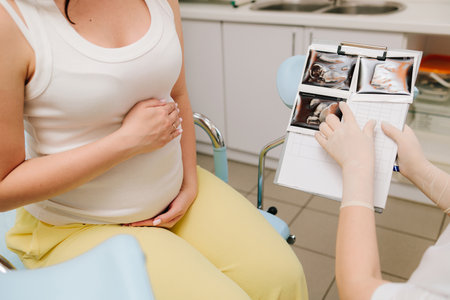 Gynecologist doctor consults patient expecting a baby about pregnancy during checkup. Pregnant woman...
