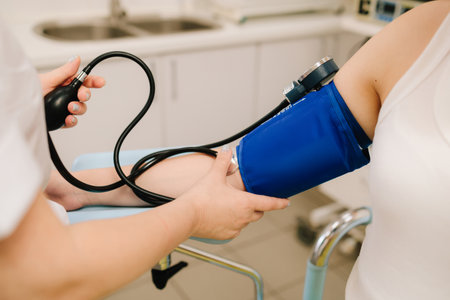 High pressure problem during pregnancy. Gynecologist measures blood pressure for pregnant patient in...
