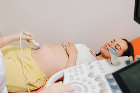 Pregnant woman on ultrasound examination at hospital. Pregnancy health checkup with ultrasound equipmentの写真素材