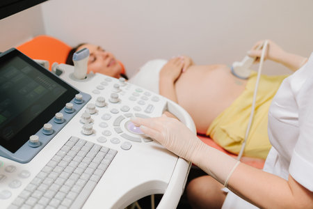 Pregnant woman on ultrasound examination at hospital. Pregnancy health checkup with ultrasound equipmentの写真素材