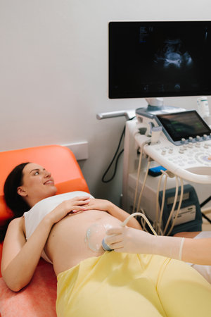 Pregnancy health checkup with ultrasound equipment. Pregnant woman on ultrasound examination at hospitalの写真素材