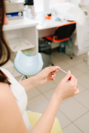 Happy future mother holds positive pregnancy test with positive result in gynecology clinicの写真素材