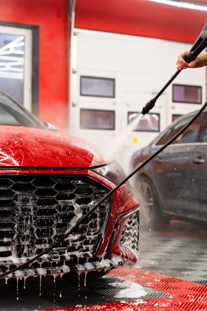 Milky pre-wash foam in auto detailing loosens contaminants from paint. Snow foam car wash coats the vehicle in a milk-like layer, safely lifting dirt and road grime before detailingの写真素材