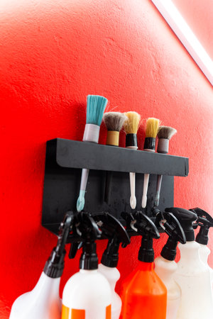 Detailing car cleaning bottles and brushes aligned neatly against neon lighting. Brushes and spray bottles neatly organized for car detailingの写真素材