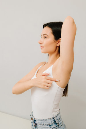 Checking for benign moles. Examination of skin neoplasm and lesions of young woman. Dermatologist examines moles or birthmark of girl patient for revention of melanoma and skin cancer close-upの写真素材