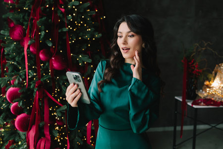 Happy woman with her phone at a Christmas and New Year party, enjoying holiday celebration