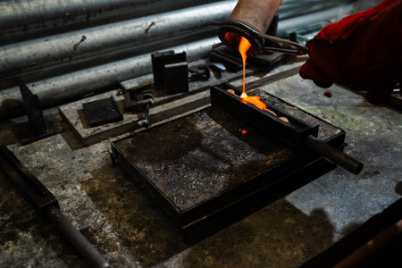 Molten gold being poured into casting mold during production