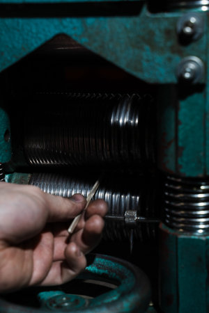 Gold metal being drawn through rolling mills