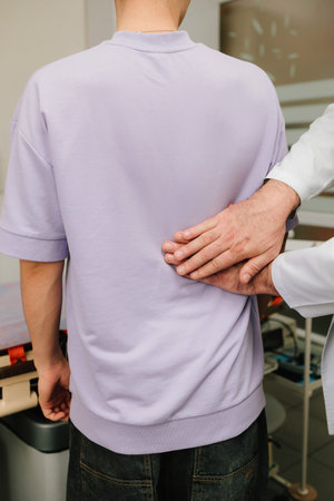 Urologist performs renal percussion to assess kidney pain during a physical examinationの写真素材