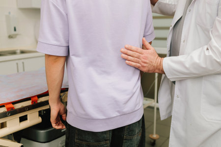 Urologist performs renal percussion to assess kidney pain during a physical examination