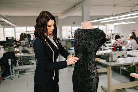 On mannequin, designer checks and hems dress for exact fit of garments and apparelの写真素材