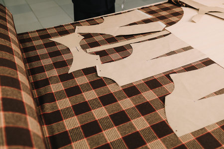 Designer lays out sewing patterns on fabric for precise garment creationの写真素材