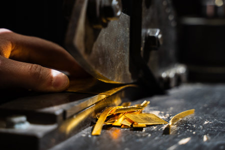 Jeweler precision slicing gold sheets using professional cutting equipmentの写真素材