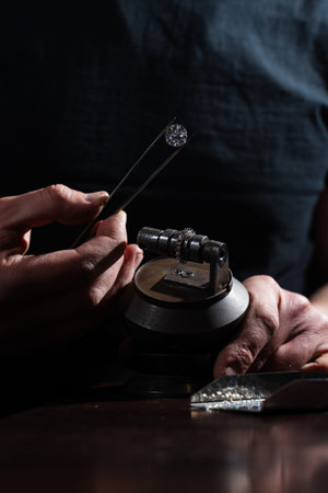 Large diamond held by artisan for close up ring inspectionの写真素材
