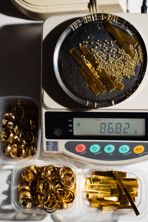 Jeweler measuring gold pieces beads and scrap prior to metal meltingの写真素材