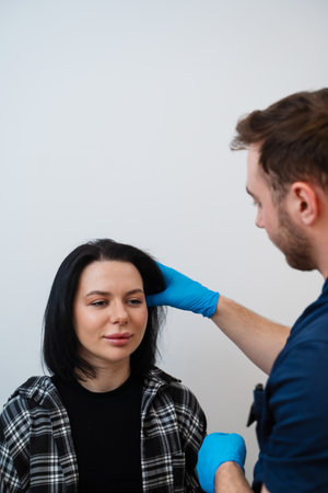 Close-up of trichologist examining hair with hands assessing strength and texture