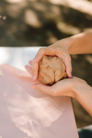 Clay molding begins with careful kneading, giving artists flexibility and strength for sculpting. Clay is kneaded to remove air and improve texture. Clay preparation in potteryの写真素材