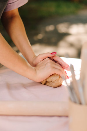 Clay molding begins with careful kneading, giving artists flexibility and strength for sculpting. Clay is kneaded to remove air and improve texture. Clay preparation in potteryの写真素材