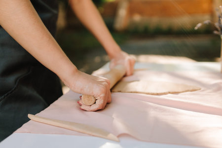 Girl prepares the clay for sculpting, enjoying the artistry and craftsmanship that define...