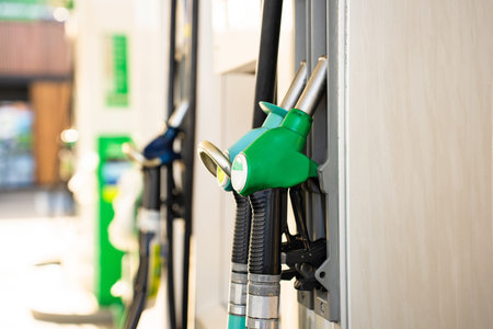 Fuel pump nozzle dispensing gasoline at modern gas station