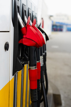 Petrol pump nozzles at service station for vehicle refueling