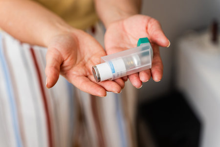 Person holding asthma inhaler isolated on white background