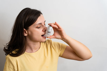 Person taking asthma inhaler for better breathing and asthma control