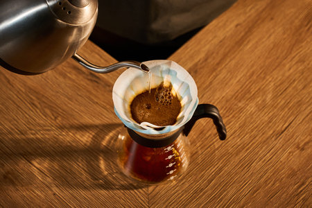 Specialty coffee brewing. Barista pours hot water into a light blue ceramic dripper