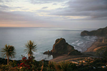 Piha at dusk, as the sun hits the beachの写真素材