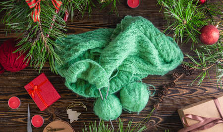 Cozy warm sweater in the process of knitting on the needles. Concept of creating handmade gifts for New year and Christmas.の写真素材