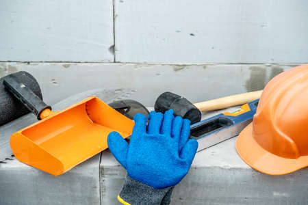 Set of construction tools on the background of a wall of aerated concrete blocks on a building site.の写真素材