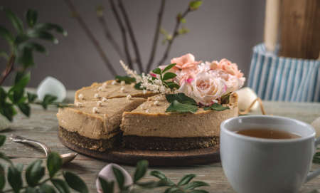Delicious and beautiful raw cake decorated with tenderness fresh flowers. Concept of romantic mood and spring atmosphere.の写真素材